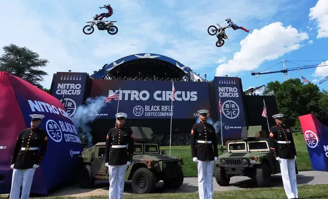 Motorsports athletes and stunt performers do a motorcycle jump ahead of the UFC Freedom 250 fights on the South Lawn of the White House, Saturday, June 13, 2026, in Washington. (AP Photo/Alex Brandon, Pool)