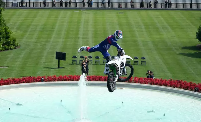A motor sports athlete and stunt performer does a motorcycle jump ahead of the UFC Freedom 250 fights on the South Lawn of the White House, Saturday, June 13, 2026, in Washington. (AP Photo/Mark Schiefelbein, Pool)