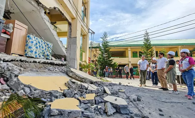 In this handout photo provided by the Presidential Communications Office, Philippine President Ferdinand Marcos Jr., third from right, talks during his visit at an earthquake damaged school in General Santos city, Philippines, Wednesday, June 10, 2026. (Presidential Communications Office via AP)