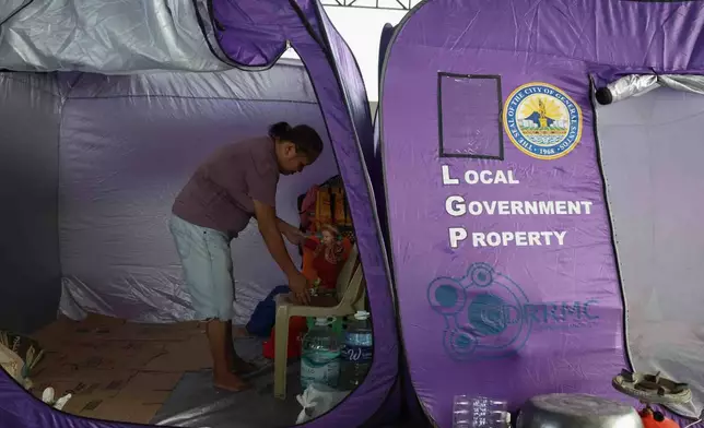 Mary Jean Lacsi takes shelter at a covered court turned into an evacuation center in General Santos, southern Philippines, Thursday, June 11, 2026, after Monday's earthquake destroyed her home. (AP Photo/Basilio Sepe)