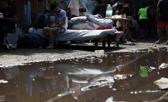 Residents gather their belongings as they evacuate from their damaged homes in General Santos, southern Philippines, Thursday, June 11, 2026, following Monday's powerful earthquake. (AP Photo/Basilio Sepe)