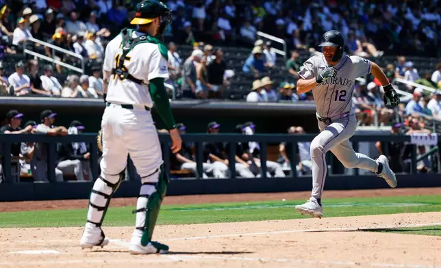 Colorado Rockies' Kyle Karros (12) runs home to score on a sacrifice fly by Braxton Fulford (37) during the fifth inning of a baseball game against the Athletics, Sunday, June 14, 2026, in Las Vegas. (AP Photo/Caroline Brehman)