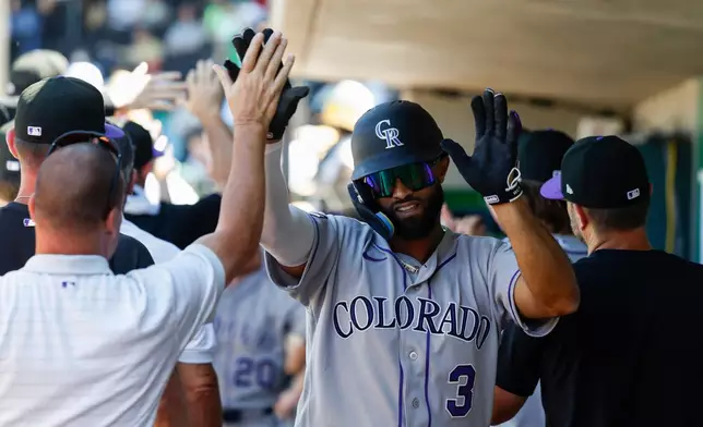 Colorado Rockies' Willi Castro (3) is greeted by teammates after hitting a grand slam during the eighth inning of a baseball game against the Athletics, Sunday, June 14, 2026, in Las Vegas. (AP Photo/Caroline Brehman)