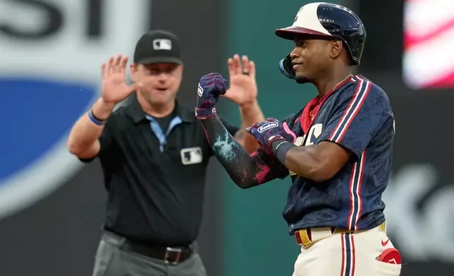 Cleveland Guardians' Angel Martínez gestures from second base in front of second base umpire Mike Muchlinski, rear, after hitting a double in the sixth inning of a baseball game against the Detroit Tigers in Cleveland, Friday, June 12, 2026. (AP Photo/Sue Ogrocki)