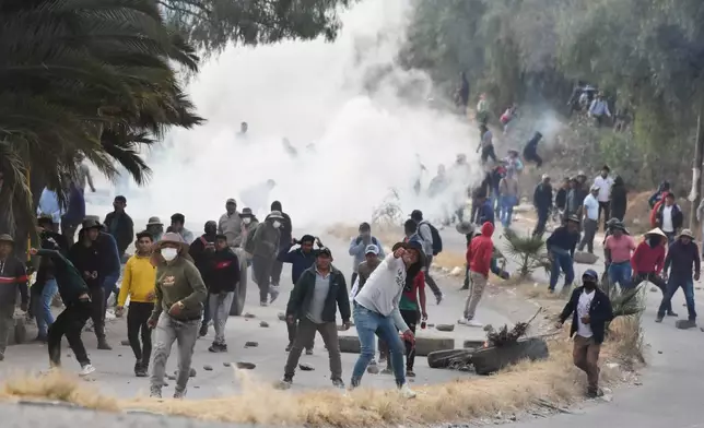 Anti-government protesters blocking a highway sling stones at military police during clashes in Vinto, Bolivia, Monday, June 8, 2026. (AP Photo/Dico Soliz)