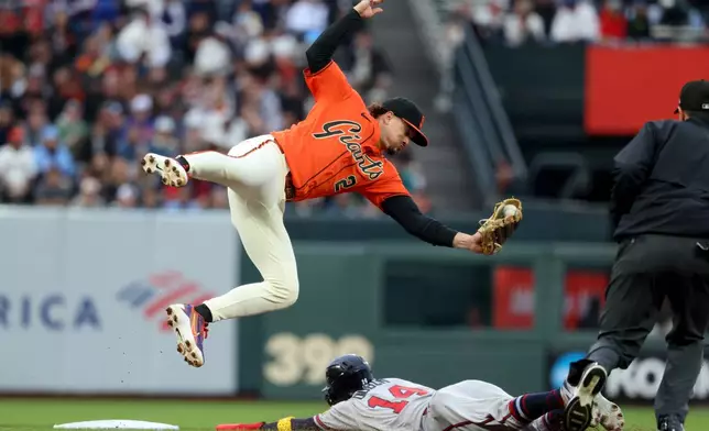 Atlanta Braves' Mauricio Dubón (14) steals second base as San Francisco Giants shortstop Willy Adames (2) fields the throw during the first inning of a baseball game in San Francisco, Friday, June 26, 2026. (AP Photo/Jed Jacobsohn)