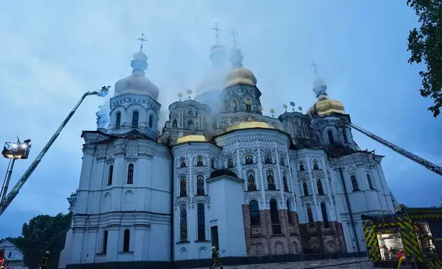 Rescue workers tries to put out a fire at the Kyiv-Pechersk Lavra, also known as the Monastery of the Caves, following a Russian strike in Kyiv, Ukraine, Monday, June 15, 2026. (AP Photo/Efrem Lukatsky)