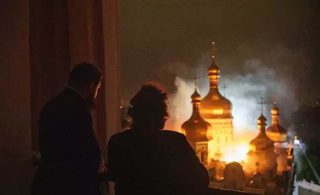 Bishop Avraamiy, right, of the Kyiv-Pechersk Lavra of the Orthodox Church of Ukraine, looks at the burning Dormition Cathedral of Kyiv-Pechersk Lavra, also known as the Monastery of the Caves, during a Russian strike on Kyiv, Ukraine, on Monday, June 15, 2026. (AP Photo/Evgeniy Maloletka)