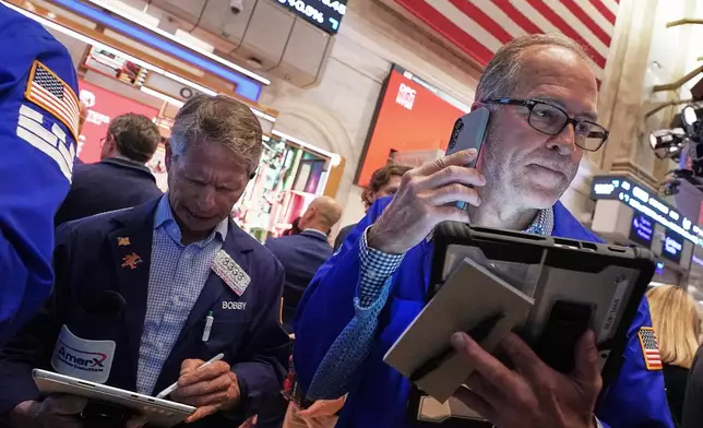 Traders Robert Charmak, left, and Mark Puetzer work on the floor of the New York Stock Exchange, Thursday, June 25, 2026. (AP Photo/Richard Drew)