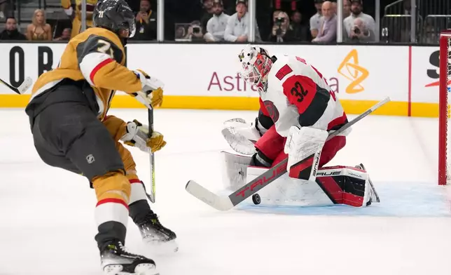Carolina Hurricanes goaltender Brandon Bussi, right, stops a shot by Vegas Golden Knights center William Karlsson during overtime in Game 3 of the NHL hockey Stanley Cup Final series Saturday, June 6, 2026, in Las Vegas. (AP Photo/John Locher)