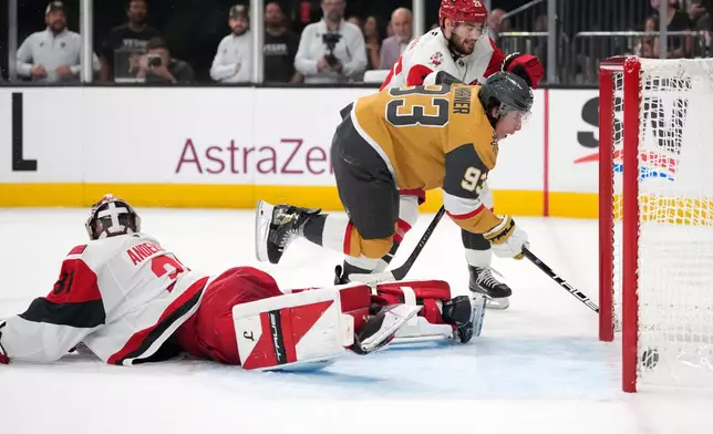 Vegas Golden Knights right wing Mitch Marner, right, scores on Carolina Hurricanes goaltender Frederik Andersen during the second period in Game 3 of the NHL hockey Stanley Cup Final series Saturday, June 6, 2026, in Las Vegas. (AP Photo/John Locher)