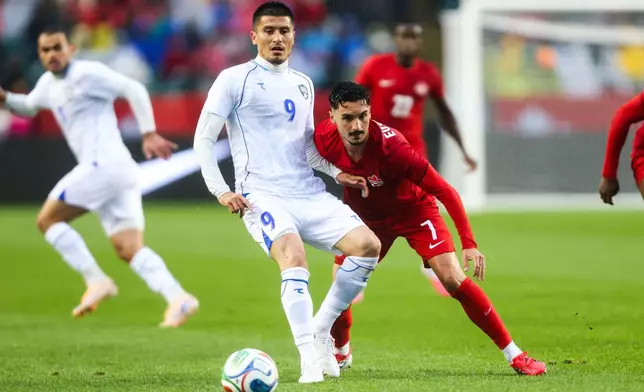 Canada's Stephen Eustaquio (7) battles against Uzbekistan's Odiljon Xamrobekov (9) during the first half of an international friendly soccer match in Edmonton, Alberta, Monday, June 1, 2026. (Codie McLachlan/The Canadian Press via AP)