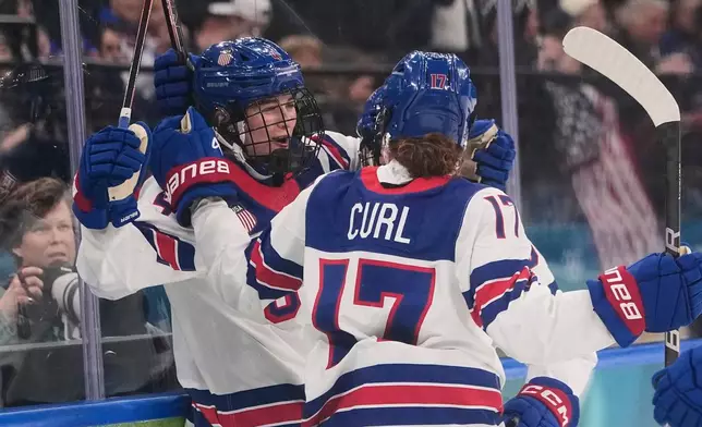 FILE - United States' Caroline Harvey celebrates with teammates after scoring her side's first goal during a preliminary round match of women's ice hockey between USA and Canada at the 2026 Winter Olympics, in Milan, Feb. 10, 2026. (AP Photo/Petr David Josek, File)