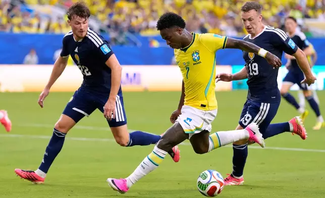 Brazil's Vinicius Junior (7) battles for the ball with with Scotland's Nathan Patterson (22) and Lewis Ferguson (19) during the World Cup Group C soccer match between Scotland and Brazil in Miami Gardens, Fla., Wednesday, June 24, 2026. (AP Photo/Rebecca Blackwell)