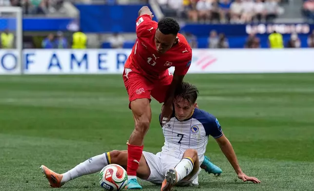 Switzerland's Dan Ndoye (11) battles for the ball with Bosnia's Amar Dedic (7), right, during the World Cup Group B soccer match between Switzerland and Bosnia in Inglewood, Calif, near Los Angeles, Thursday, June 18, 2026. (AP Photo/Gregory Bull)