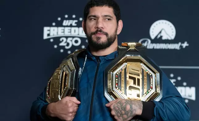 Former UFC light heavyweight champion Alex Pereira from Brazil, holds his championship belts during the UFC Freedom 250 media day, Wednesday, June 10, 2026, in Washington. (AP Photo/Manuel Balce Ceneta)