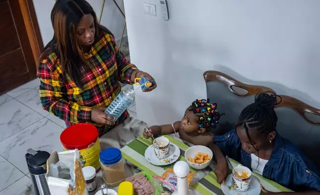 Gloria Masanka, a mother of two daughters, spends time with them at home in Kinshasa, Congo, Monday, April 6, 2026. (AP Photo/Samy Ntumba Shambuyi)