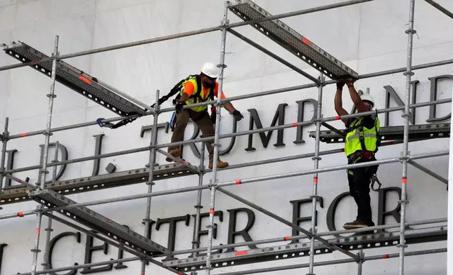 Workers construct scaffolding at the sign for the John F. Kennedy Center for the Performing Arts, Friday, June 12, 2026, in Washington. (AP Photo/Rahmat Gul)