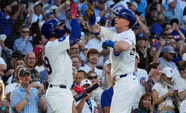 Chicago Cubs' Pete Crow-Armstrong, right, celebrates with Michael Busch after hitting a solo home run during the first inning of a baseball game against the Colorado Rockies in Chicago, Monday, June 15, 2026. (AP Photo/Nam Y. Huh)