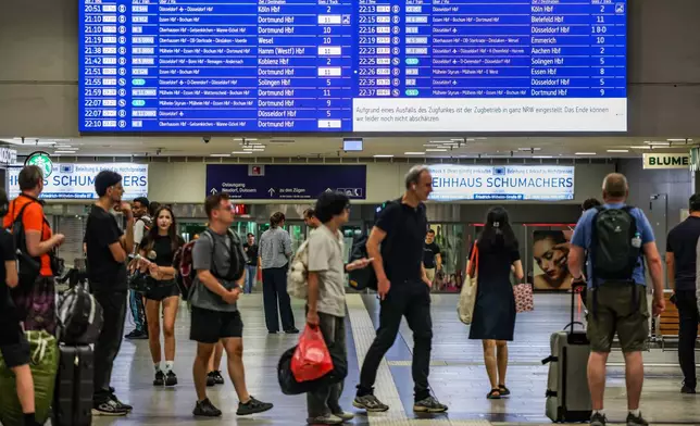 Passengers line up at the DB information desk at the Duisburg train station, Tuesday, June 23, 2026. (Christoph Reichwein/dpa via AP)
