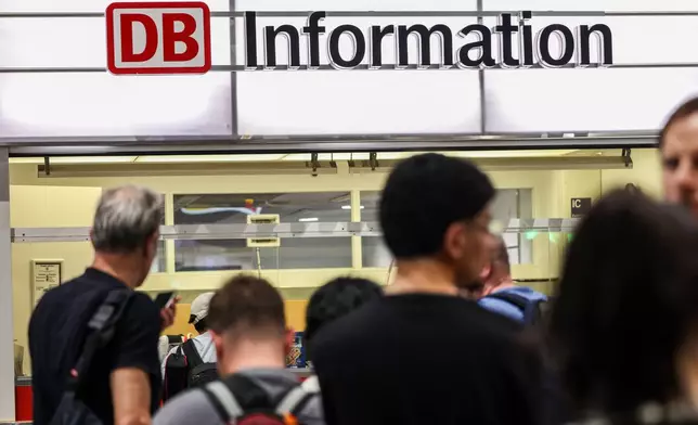 Passengers line up at the DB information desk at the Duisburg train station, Tuesday, June 23, 2026, (Christoph Reichwein/dpa via AP)
