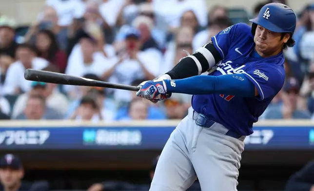 Los Angeles Dodgers designated hitter Shohei Ohtani hits a solo home run against the Minnesota Twins during the first inning of a baseball game, Monday, June 22, 2026, in Minneapolis. (AP Photo/Matt Krohn)