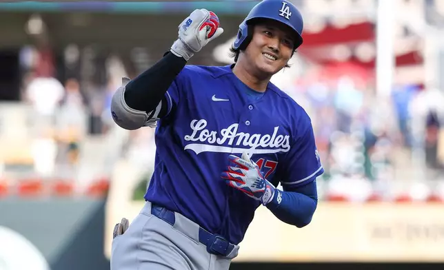 Los Angeles Dodgers designated hitter Shohei Ohtani celebrates as he runs the bases on his solo home run against the Minnesota Twins during the first inning of a baseball game, Monday, June 22, 2026, in Minneapolis. (AP Photo/Matt Krohn)