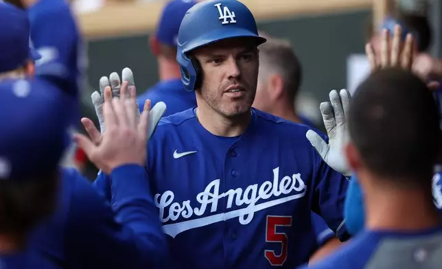 Los Angeles Dodgers' Freddie Freeman celebrates his solo home run with teammates during the sixth inning of a baseball game, Monday, June 22, 2026, in Minneapolis. (AP Photo/Matt Krohn)
