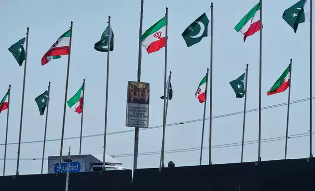 The welcoming billboard, featuring Iranian President Masoud Pezeshkian, right, with Pakistan President Asif Ali Zardari, center, and Prime Minister Shehbaz Sharif, is displayed alongside of an overhead bridge, in Islamabad, Pakistan, Tuesday, June 23, 2026. (AP Photo/Anjum Naveed)