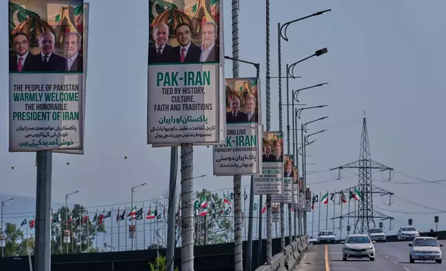 Vehicles drives past welcoming billboards featuring Iranian President Masoud Pezeshkian, right, with Pakistan President Asif Ali Zardari, center, and Shehbaz Sharif alongside an overhead bridge in Islamabad, Pakistan, Tuesday, June 23, 2026. (AP Photo/Anjum Naveed)