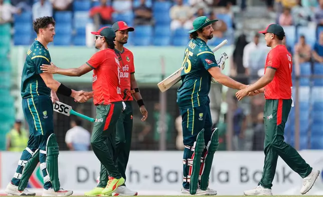 Bangladesh's players congratulate Australia's Tim David, center, and Matt Renshaw, left, after Australia won the third T20 international cricket match between Australia and Bangladesh, in Chattogram, Bangladesh, Sunday, June 21, 2026. (AP Photo/Mosaraf Hossain)