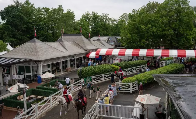 Jockeys walk thoroughbreds to the track for the second race of the day before the 158th running of the Belmont Stakes horse race at Saratoga Race Course, Saturday, June 6, 2026, in Saratoga Springs, N.Y. (AP Photo/Yuki Iwamura)