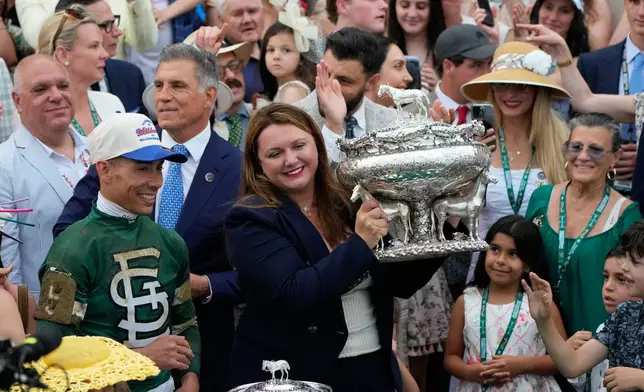 Trainer Cherie DeVaux, center, with Jockey Jose Ortiz, left, holds the trophy after Golden Tempo won the 158th running of the Belmont Stakes horse race, Saturday, June 6, 2026, in Saratoga Springs, N.Y. (AP Photo/Yuki Iwamura)