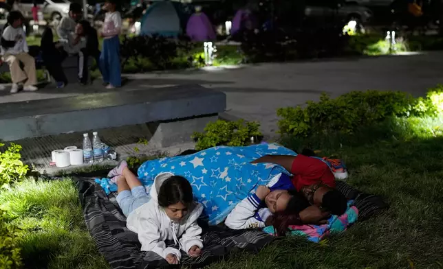 People camp out the night after earthquakes struck Caracas, Venezuela, Thursday, June 25, 2026 (AP Photo/Ariana Cubillos)