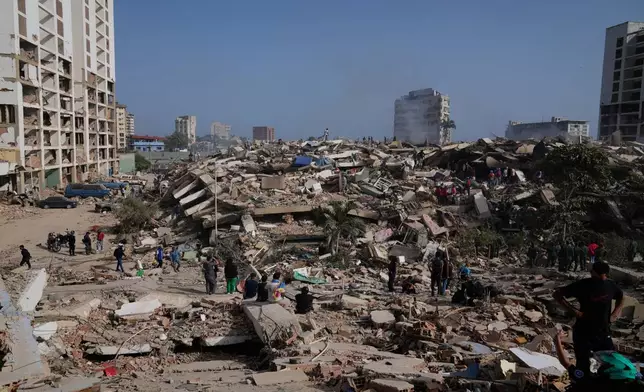 People search through the rubble two days after an earthquake struck La Guaira, Venezuela, Friday, June 26, 2026. (AP Photo/Ariana Cubillos)