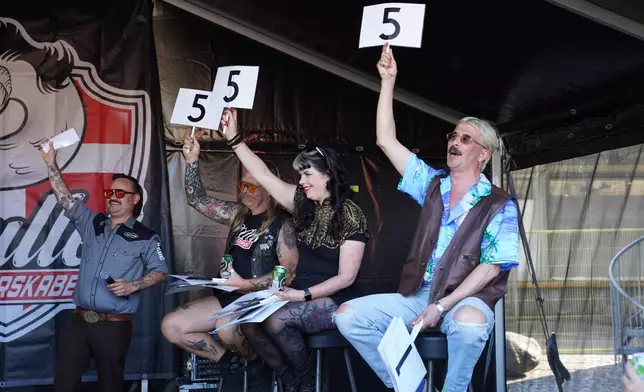 Judges hold scorecards at Denmark's Mullet Championship in central Copenhagen, Saturday, June 6, 2026. (AP Photo/James Brooks)