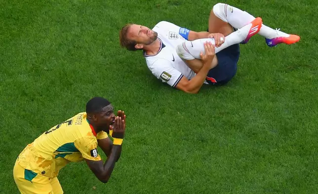 Ghana's Thomas Partey, left, argues with the referee after tripping up England's Harry Kane, top, during the second half of a World Cup Group L soccer match in Foxborough, Mass., near Boston, Tuesday, June 23, 2026. (AP Photo/Steven Senne)