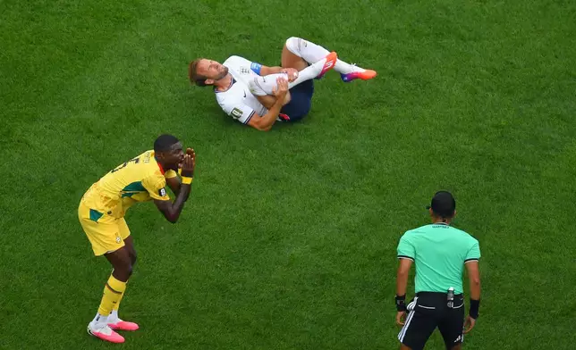 Ghana's Thomas Partey, left, argues with referee Said Martinez, right, after tripping up England's Harry Kane, top, during the second half of a World Cup Group L soccer match in Foxborough, Mass., near Boston, Tuesday, June 23, 2026. (AP Photo/Steven Senne)