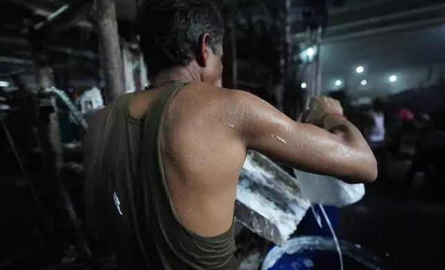 Sweat is visible on a worker on a hot day at Vinit Fabrics in Palsana near Surat, India, Tuesday, May 26, 2026. (AP Photo/Ajit Solanki)