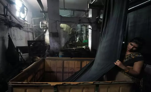 Soni Pande works at a textile factory on a hot day in Sachin near Surat, India, Wednesday, May 27, 2026. (AP Photo/Ajit Solanki)