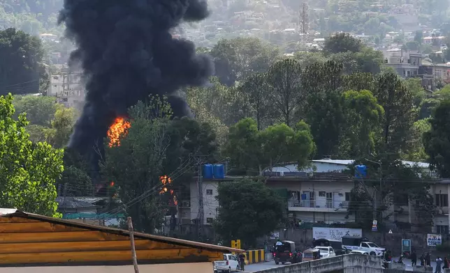 Smoke billows after an army MI-17 helicopter crashed due to a technical fault, in Muzaffarabad, capital of Pakistan-administered Kashmir, Wednesday, June 10, 2026. (AP Photo/M.D. Mughal)