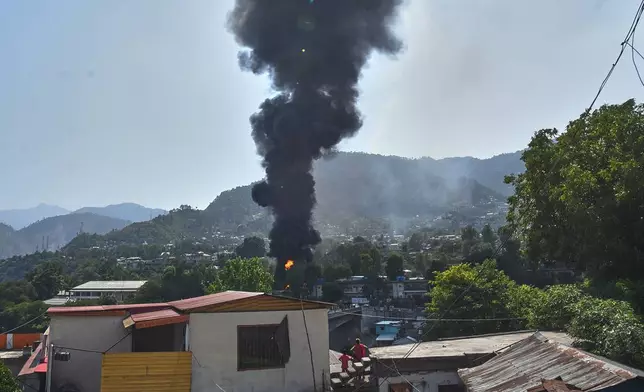 Smoke billows after an army MI-17 helicopter crashed due to a technical fault, in Muzaffarabad, capital of Pakistan-administered Kashmir, Wednesday, June 10, 2026. (AP Photo/M.D. Mughal)
