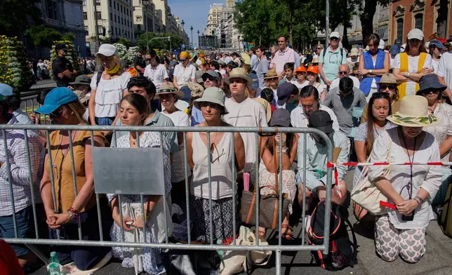 People attend a Mass presided over by Pope Leo XIV, marking the Catholic feast of Corpus Christi at Plaza de Cibeles in Madrid, Spain, Sunday, June 7, 2026, on the second day of his seven-day apostolic visit to mainland Spain and the Canary Islands. (AP Photo/Andrea Comas)