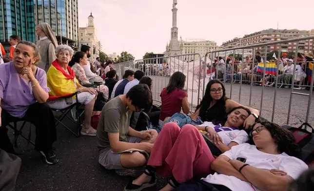 People wait for the arrival of Pope Leo XIV ahead of a Holy Mass and Corpus Christi procession at Plaza de Cibeles in Madrid, Spain, Sunday, June 7, 2026, on the second day of his seven-day apostolic visit to mainland Spain and the Canary Islands. (AP Photo/Andrea Comas)