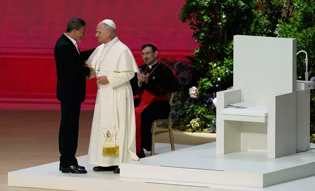 Pope Leo XIV greets Antonio Banderas as he attends the meeting "Building networks with the world of culture, art, economy and sport" at the Movistar Arena in Madrid, Spain, Sunday, June 7, 2026. (AP Photo/Andrea Comas)