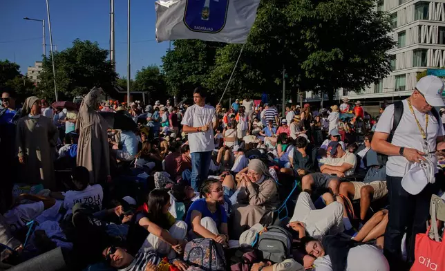 People wait for the arrival of Pope Leo XIV ahead of a Holy Mass and Corpus Christi procession at Plaza de Cibeles in Madrid, Spain, Sunday, June 7, 2026, on the second day of his seven-day apostolic visit to mainland Spain and the Canary Islands. (AP Photo/Andrea Comas)