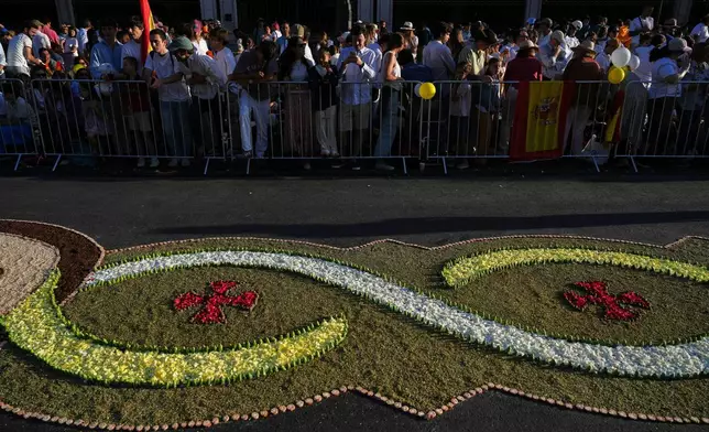 People wait for Pope Leo XIV to preside over Mass marking the Catholic feast of Corpus Christi in Plaza de Cibeles in Madrid, Sunday, June 7, 2026, on the second day of a seven-day apostolic journey to mainland Spain and the Canary Islands. (AP Photo/Alessandra Tarantino)