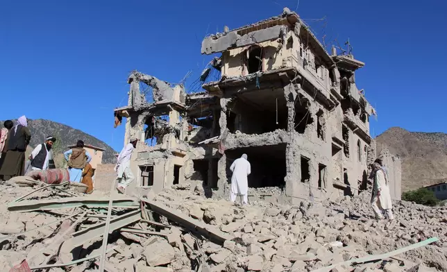 Residents walk through the rubble after what Taliban officials said were Pakistani airstrikes a day earlier that killed civilians, including children, in the village of Mandokhail, Chamkani district, Paktia province, Afghanistan, Monday, June 29, 2026. (AP Photo/Saifullah Zahir)
