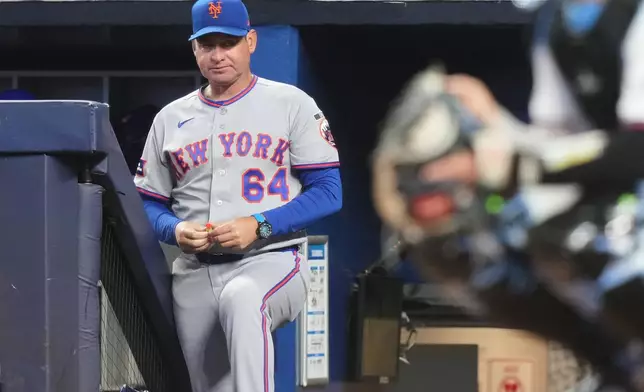 FILE - New York Mets manager Carlos Mendoza (64) watches during the first inning of a baseball game against the Miami Marlins, Saturday, May 23, 2026, in Miami. (AP Photo/Lynne Sladky, File)