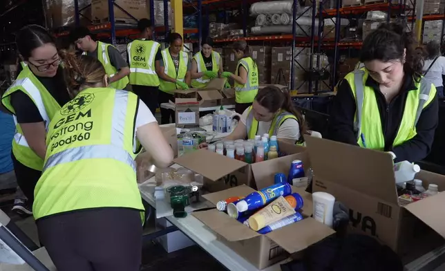 Volunteers are seen packaging supplies, Thursday, June 25, 2026, in Doral, Fla. (AP Photo/Cody Jackson)